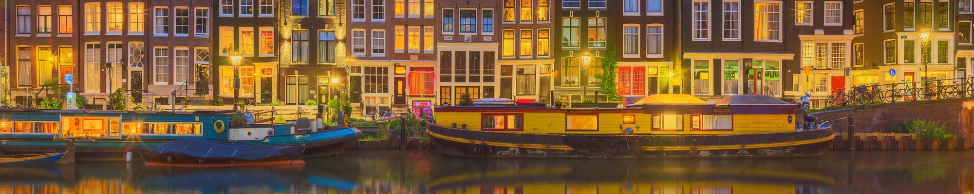 Hausbote auf Kanal vor historischen Häusern - als Symbolbild für den Paketversand nach Rotterdam / Niederland